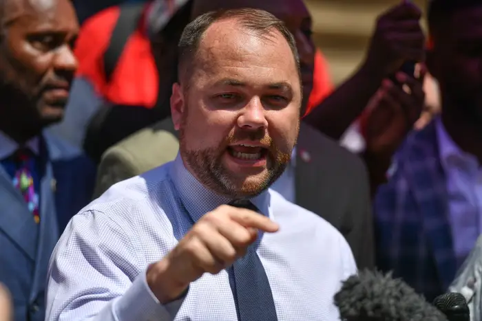 City Council Speaker Corey Johnson speaks at a lectern on a hot summer day in 2019.